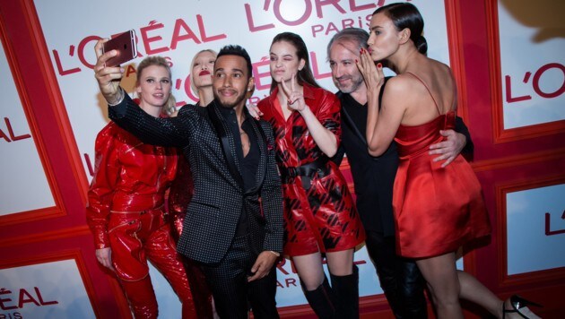 "Lebemann" Lewis Hamilton mit Models bei einer Werbeveranstaltung (Bild: AP)