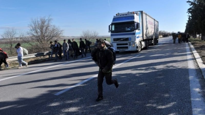 Flüchtlinge versuchen, über die Autobahn nach Mazedonien zu gelangen. (Bild: APA/AFP/SAKIS MITROLIDIS)