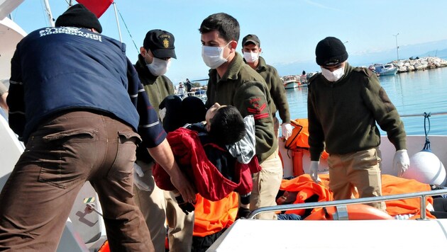 Die türkische Küstenwache mit einem ertrunkenen Buben. (Bild: APA/AFP/STR)