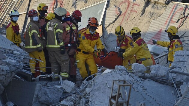 Rettungskräfte bergen die Achtjährige aus dem eingestürzten Wei-Kuan-Hochhaus. (Bild: APA/AFP/Sam Yeh)