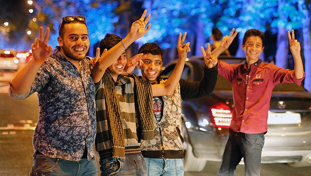 Junge Iraner feiern den Durchbruch im Atom-Streit in Teheran. (Bild: APA/EPA/ABEDIN TAHERKENAREH)