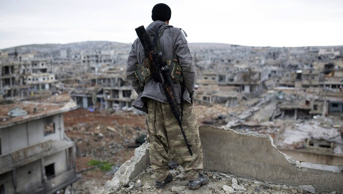 Ein kurdischer Scharfschütze blickt auf die Ruinen der syrischen Grenzstadt Kobane.