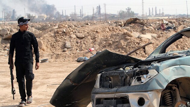 Ein irakisch-schiitischer Milizionär vor der jüngst vom IS zurückeroberten Ölraffinierie in Baiji (Bild: APA/EPA/Haider al-Assadee)