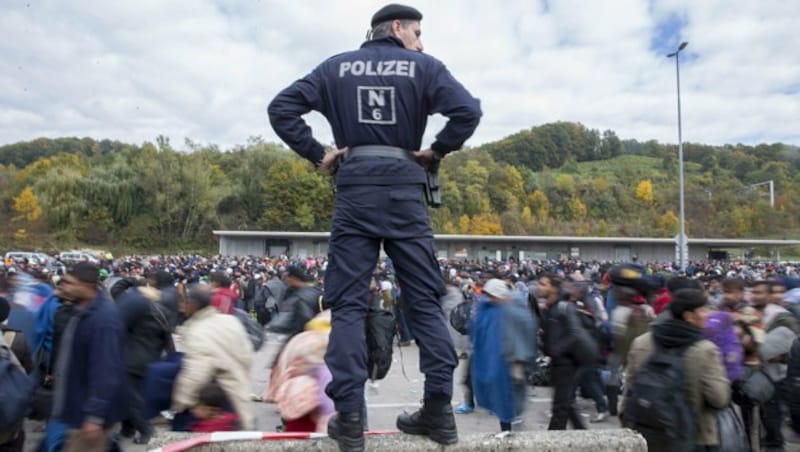 Flüchtlinge überqueren die Absperrungen im Sammelzentrum an der Grenze in Spielfeld. (Bild: APA/ERWIN SCHERIAU)