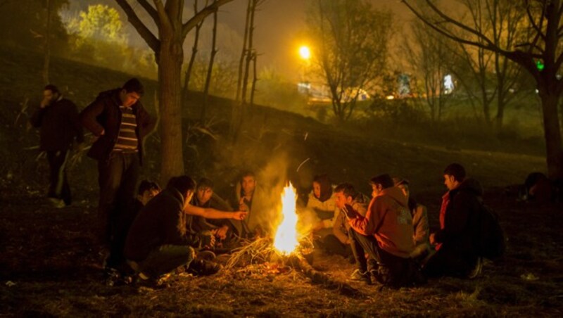 Flüchtlinge wärmen sich an der steirisch-slowenischen Grenze an einem Lagerfeuer. (Bild: APA/ERWIN SCHERIAU)