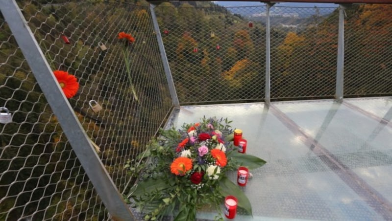 Blumen und Kerzen auf der Aussichtsplattform am Bergisel erinnern an das tragische Unglück. (Bild: Christof Birbaumer)