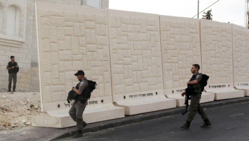 Israelische Polizisten patrouillieren entlang der derzeit in Bau befindlichen Mauer in Jerusalem. (Bild: AP)