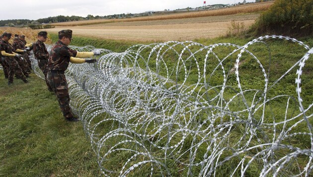 Ungarische Soldaten bauen die provisorische Sperre zu Slowenien wieder ab. (Bild: APA/EPA/Gyorgy Varga)