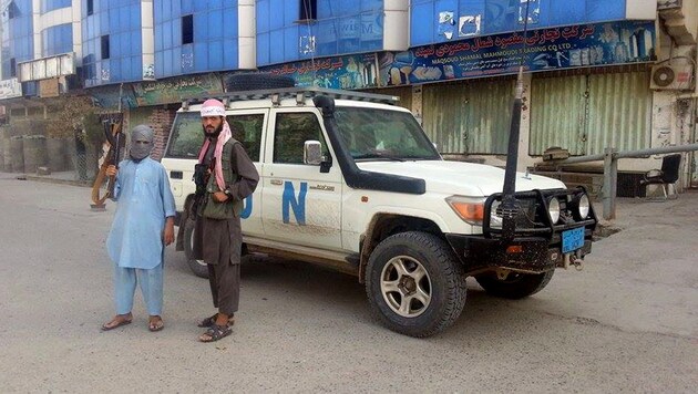 Taliban-Kämpfer posieren nach der Eroberung von Kunduz neben einem Jeep der UNO. (Bild: AP)