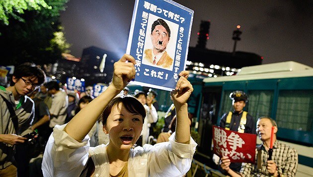 Proteste gegen die neue Militärdoktrin: Premier Shinzo Abe als Adolf Hitler. (Bild: APA/EPA/FRANCK ROBICHON)