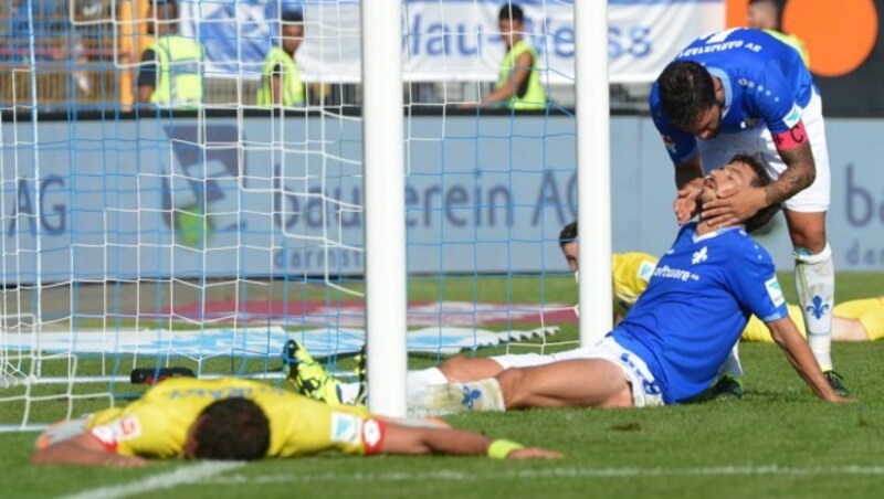 György Garics (sitzend) nach einer Rettungstat erleichtert (Bild: APA/EPA/ROLAND HOLSCHNEIDER)