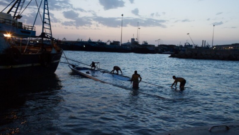 Das gesunkene Flüchtlingsboot wird aus dem Wasser geholt. (Bild: AP)