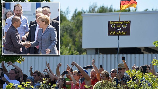 Merkel beim Handshake mit einem Flüchtling; Protest gegen die Asylpolitik der Regierung (Bild: AFP, AP)