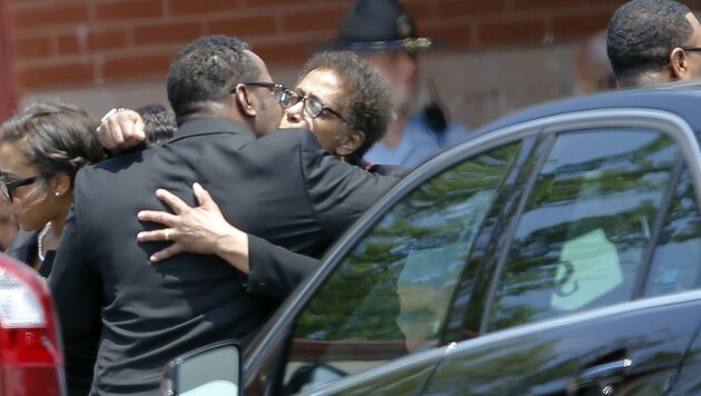 Bobbi Kristinas Vater Bobby Brown mit einer trauernden Angehörigen vor der Kapelle (Bild: AP)