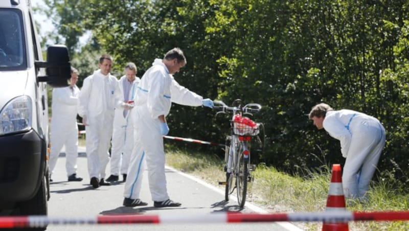 Ermittler untersuchen das Fahrrad des zweiten getöteten Opfers. (Bild: AP)