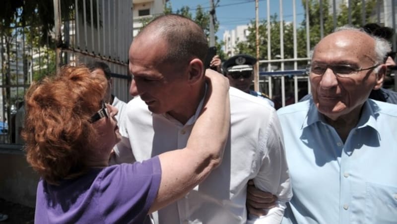 Finanzminister Varoufakis wird von einer Frau geherzt. Rechts im Bild: Varoufakis' Vater Giorgos (Bild: AP)