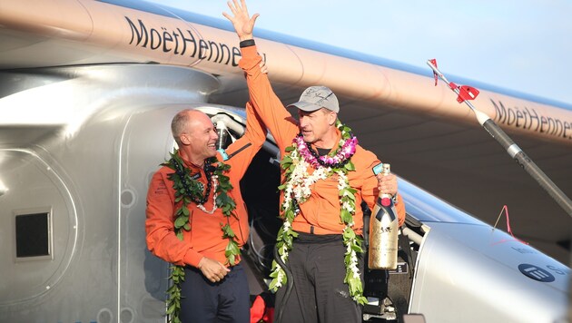 Pilot Andre Borschberg wird von seinem Kopiloten Bertrand Piccard auf Hawaii gefeiert. (Bild: APA/EPA/Bruce Omori)