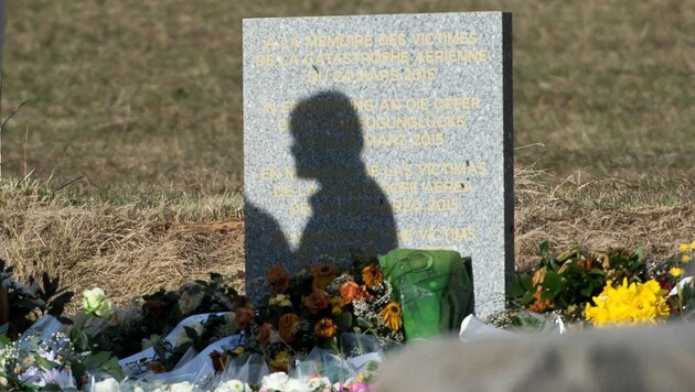 Eine Silhouette auf der im Ort Le Vernet aufgestellten Gedenktafel für die Opfer des Unglücksfluges (Bild: APA/EPA/DANIEL KARMANN)