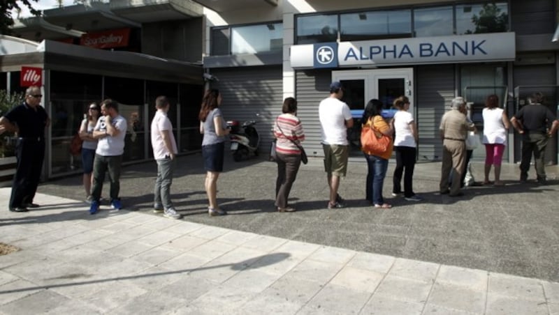 Menschen warten vor einem Bankomaten in Athen. (Bild: APA/EPA/ALEXANDROS VLACHOS)