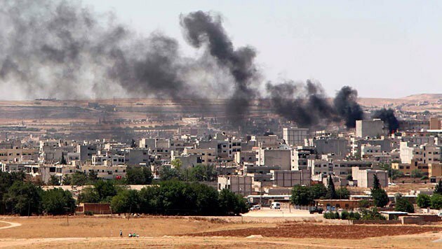 Rauchwolken über der Kurdenstadt Kobane nach einem Angriff ... (Bild: APA/EPA/STR)