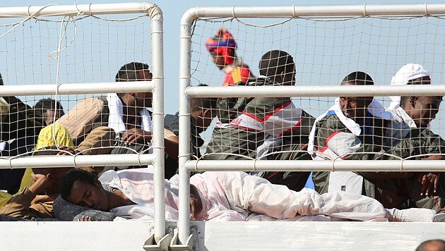 Migranten auf einem Flüchtlingsboot im Hafen der sizilianischen Stadt Augusta (Bild: AP)