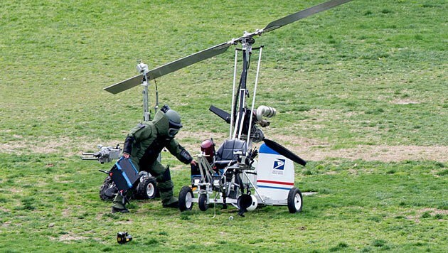 Ein Mitarbeiter des Bombenentschärfungskommandos untersucht den Hubschrauber. (Bild: APA/EPA/Michael Reynolds)