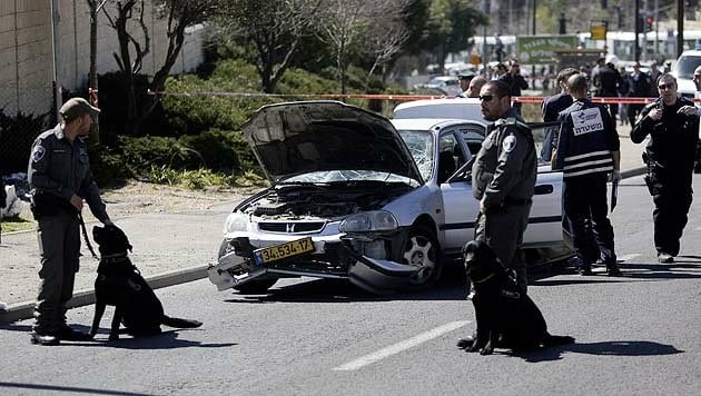 Israelische Sicherheitskräfte sichern das Auto des Attentäters. (Bild: Ap)