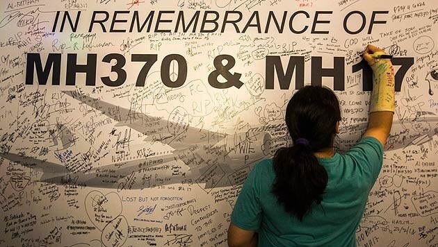 Unterschriften auf einer MH370-Gedenktafel in Kuala Lumpur (Bild: APA/EPA/AHMAD YUSNI)
