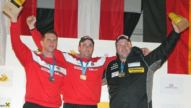 Bernhard Patschg (Mitte) jubelt über sein zweites Gold bei der Eisstock-EM im Weitschießen. (Bild: Bert Zuschnig)