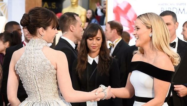 Felicity Jones und Reese Witherspoon begrüßen sich am roten Teppich. (Bild: AFP)