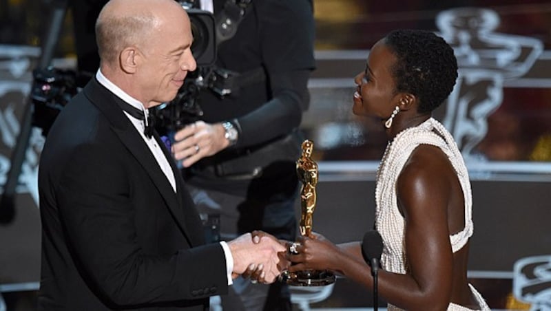 J. K. Simmons übernimmt die Trophäe von Lupita Nyong'o. (Bild: John Shearer/Invision/AP)