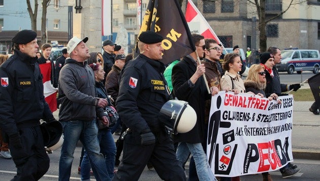 Die Teilnehmer der Pegida-Kundgebung in Linz beim "Spaziergang" zum Volksgarten und zurück (Bild: APA/RUBRA)