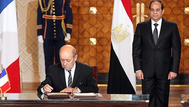 Le Drian bei der Unterschrift, im Hintergrund al-Sisi (Bild: APA/EPA/Khaled Elfiqi)