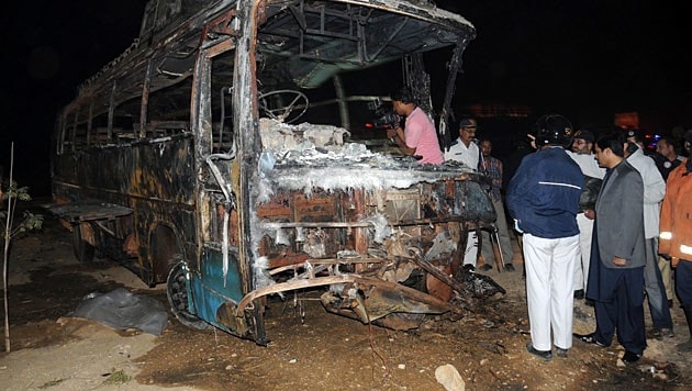 Der völlig ausgebrannte Reisebus (Bild: APA/EPA/Shahzaib Akber)