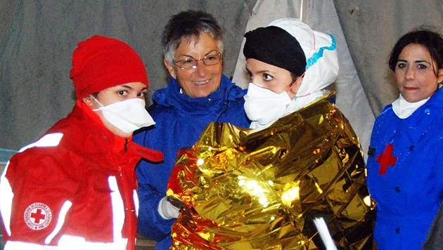 Rot-Kreuz-Mitarbeiter kümmern sich um das Neugeborene. (Bild: APA/EPA/FRANCESCO SAYA)