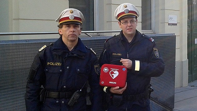 Die Lebensretter mit ihrem Defibrillator (Bild: Polizei)