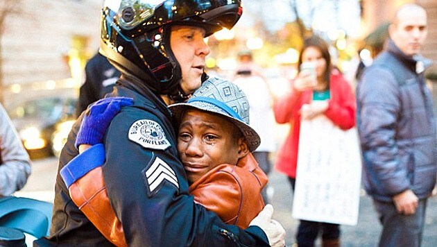 Schwarzer Bub und weißer Cop - dieses Bild aus Portland rührt die Web-Gemeinde. (Bild: Twitter/Johnny Nguyen)