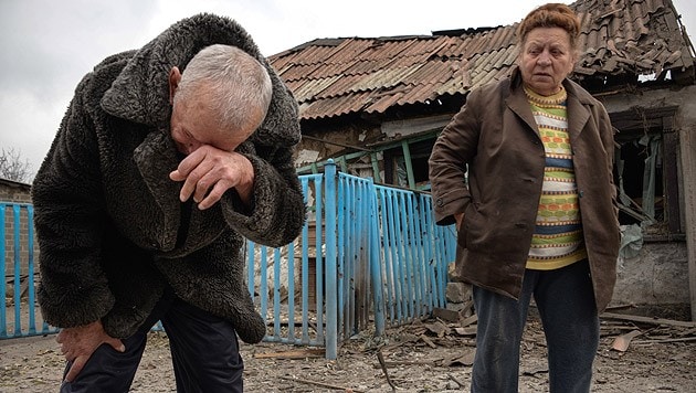 Ein Ehepaar vor den Trümmern seines Hauses in Donezk (Bild: AP)