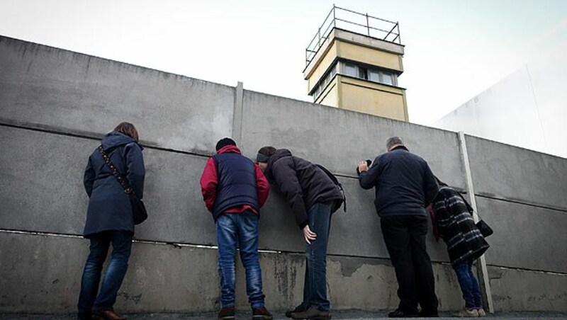 Passanten stehen an der Mauergedenkstätte in Berlin. (Bild: APA/dpa)