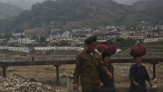 Viele Zivilisten, wie hier in Kimch'aek, müssen Dämme bauen und Schlaglöcher stopfen - von Hand. (Bild: AP)