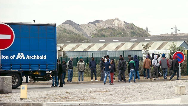 Flüchtlinge warten im Hafen von Calais auf die nächste Fluchtmöglichkeit nach Großbritannien. (Bild: AFP)