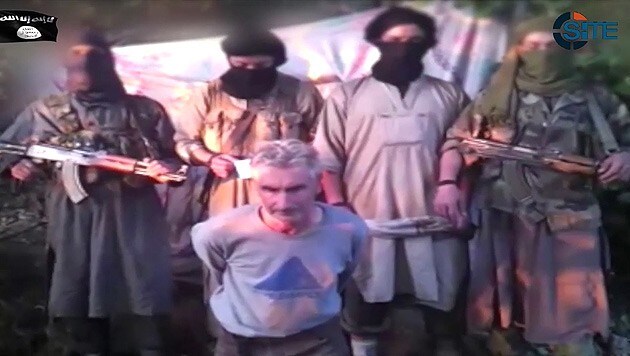 Herve Gourdel kurz vor seiner Hinrichtung umringt von "Soldaten des Kalifats" (Bild: AP)