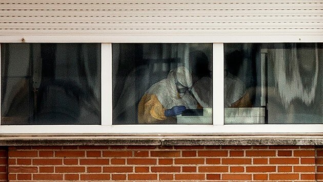 Krankenhauspersonal in Schutzanzügen überwacht die spanische Ebola-Patientin rund um die Uhr. (Bild: AP)