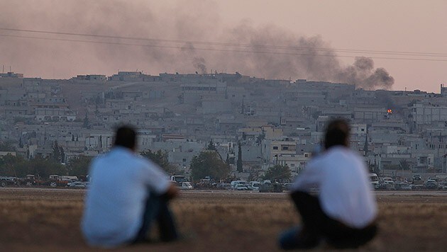 Kurden beobachten das Geschehen in Kobane von einem Hügel an der Grenze zur Türkei aus. (Bild: AP)