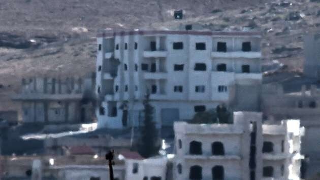 Auf einem Gebäude im Osten von Kobane wurde am Montag die Flagge der IS-Extremisten gehisst. (Bild: AFP)