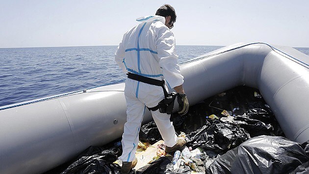 Ein Mitglied der italienischen Marine inspiziert Reiseutensilien von Flüchtlingen. (Bild: APA/EPA/GIUSEPPE LAMI)