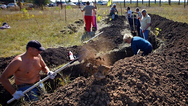 Freiwillige beim Errichten von Befestigungsanlagen, nun soll auch eine Mauer errichtet werden. (Bild: APA/EPA/SERGEY KOZLOV)