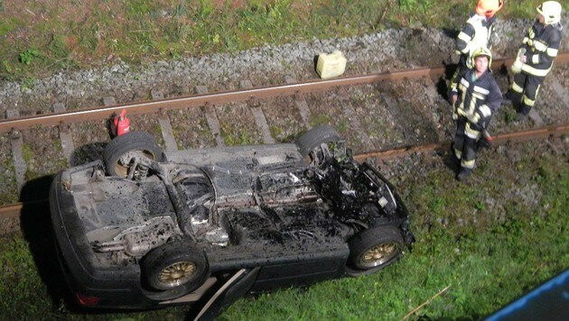 Der Wagen landete "kopfüber" auf den Bahngleisen. (Bild: APA/FF SCHARNSTEIN)