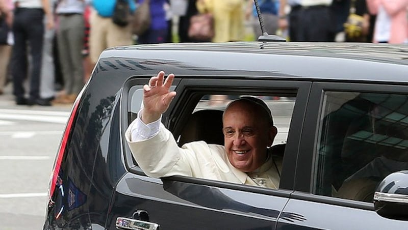 Papst Franziskus winkt Schaulustigen bei seiner Ankunft in Seoul. (Bild: AP)