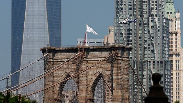 Rätsel gelöst: Zwei deutsche Künstler tauschten die Fahnen auf der Brooklyn Bridge aus. (Bild: APA/EPA/ANDREW GOMBERT)
